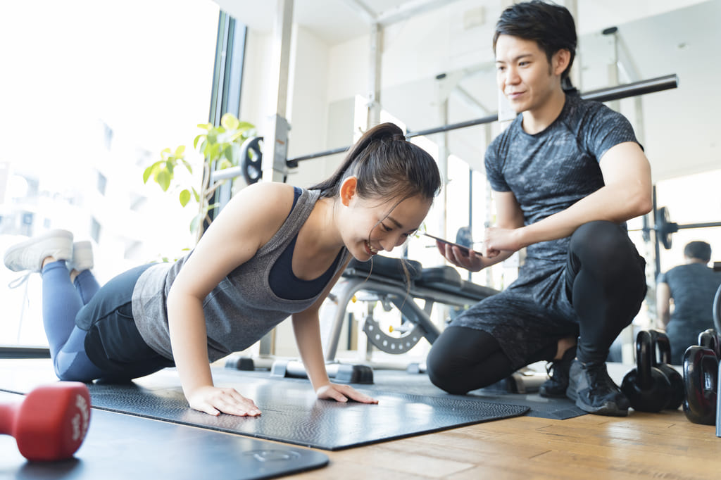 腕立て伏せをしている女性とトレーナー